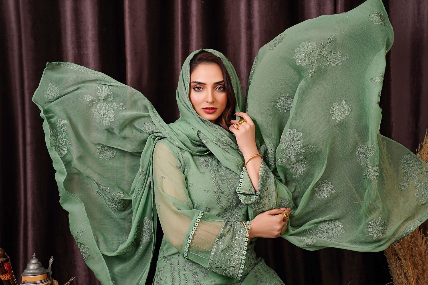 Model in a flowing sage embroidered festive suit