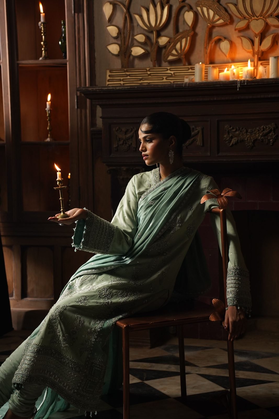 Model in a sage-green embroidered ASHQA suit by candlelight